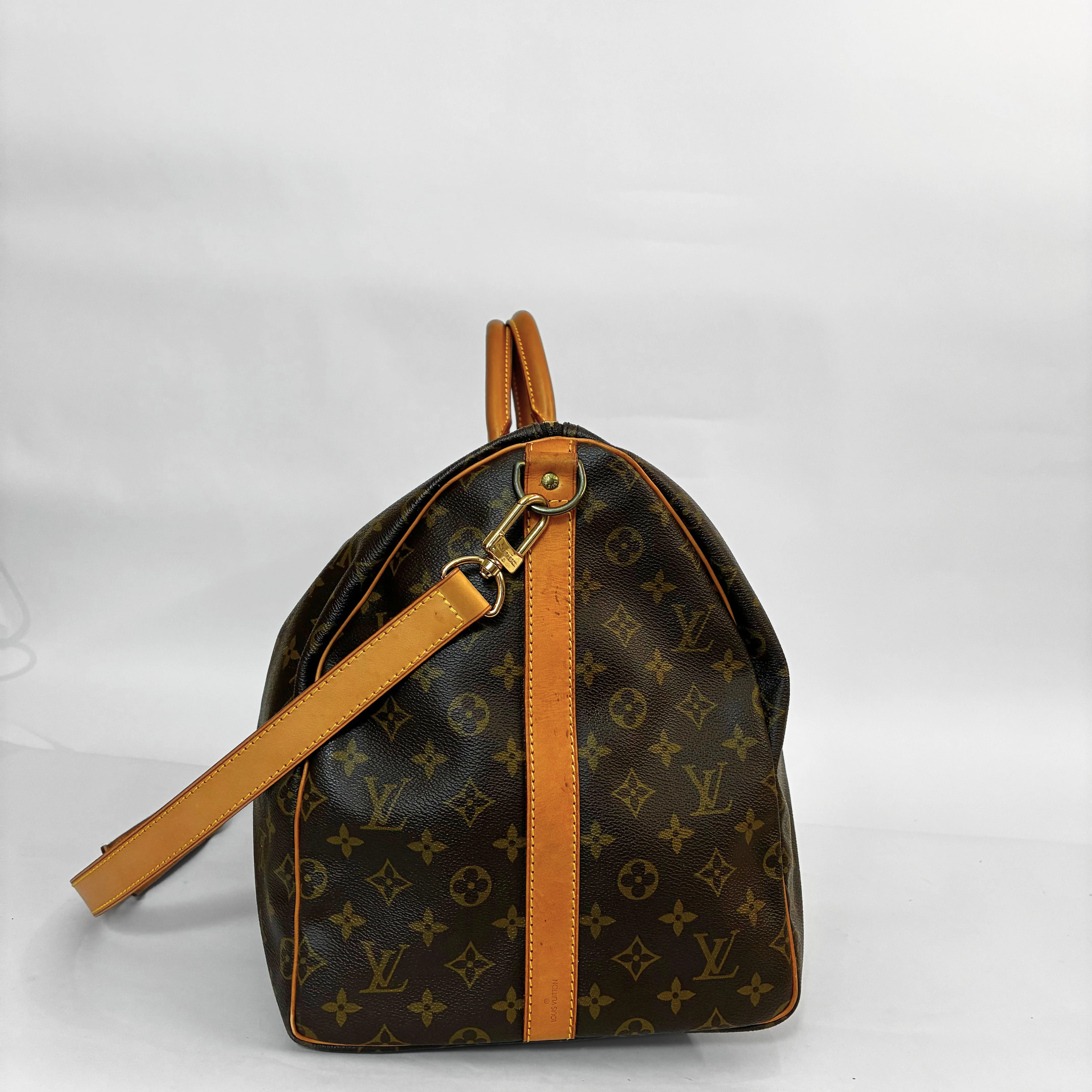 Designer handbag with monogram pattern on a white background