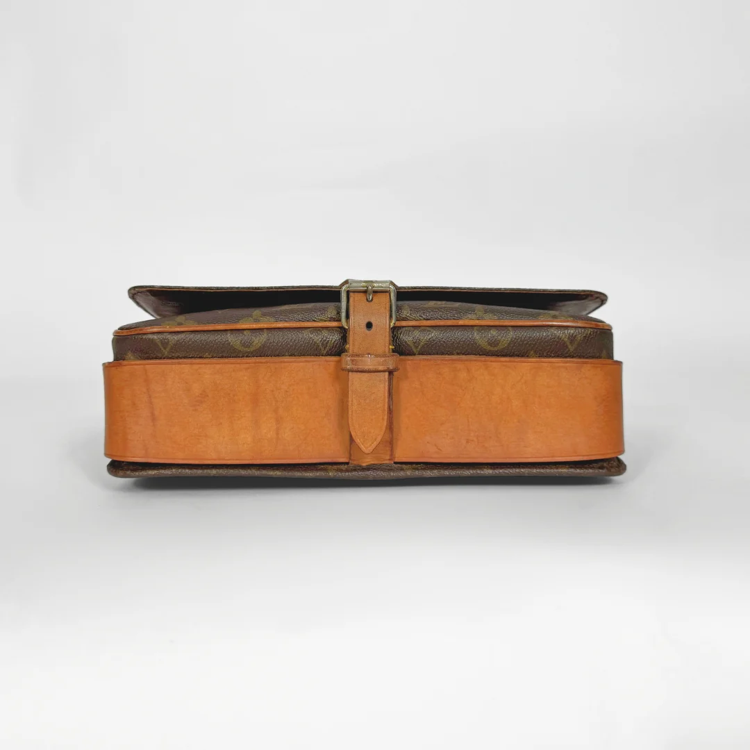 Brown leather suitcase with a strap on a white background