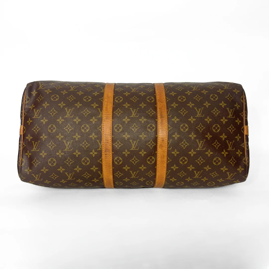 Brown monogram patterned bag with wooden accents on a white background