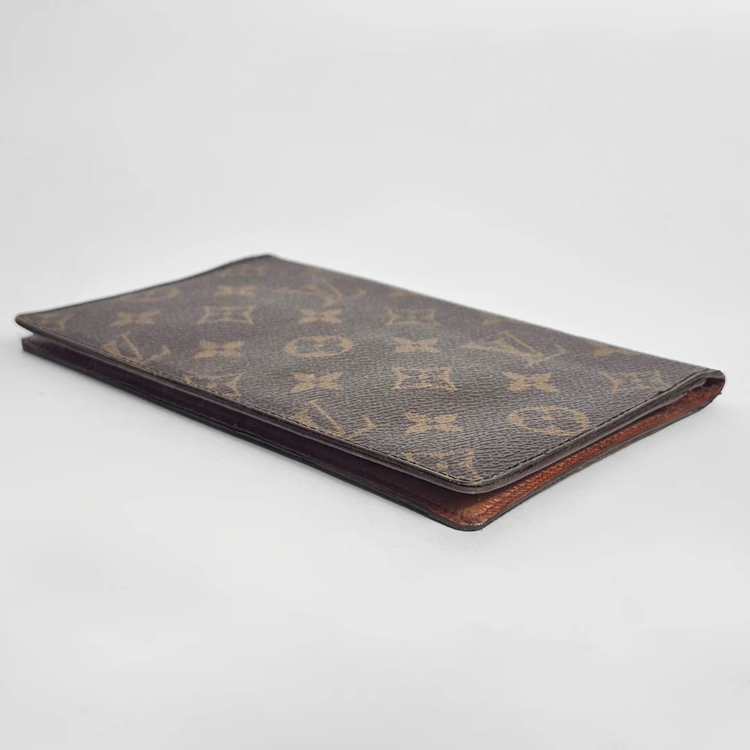 Designer wallet with monogram pattern on a light gray background
