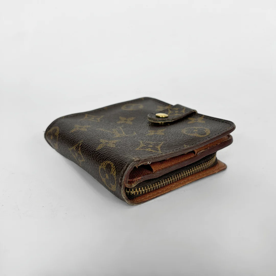 LV compact wallet in signature brown monogram canvas with a snap-button strap closure.