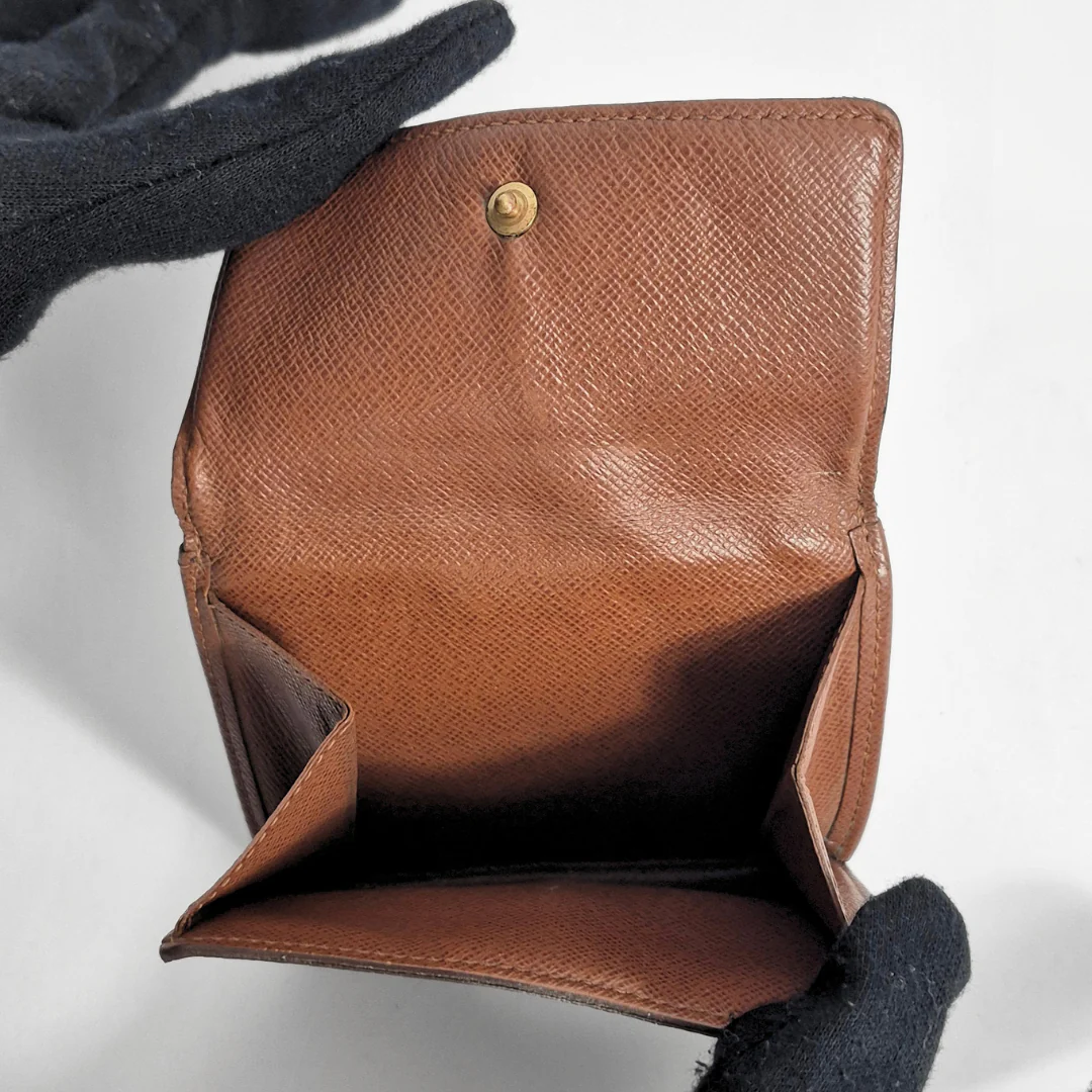 Brown leather wallet with a button on a light gray background
