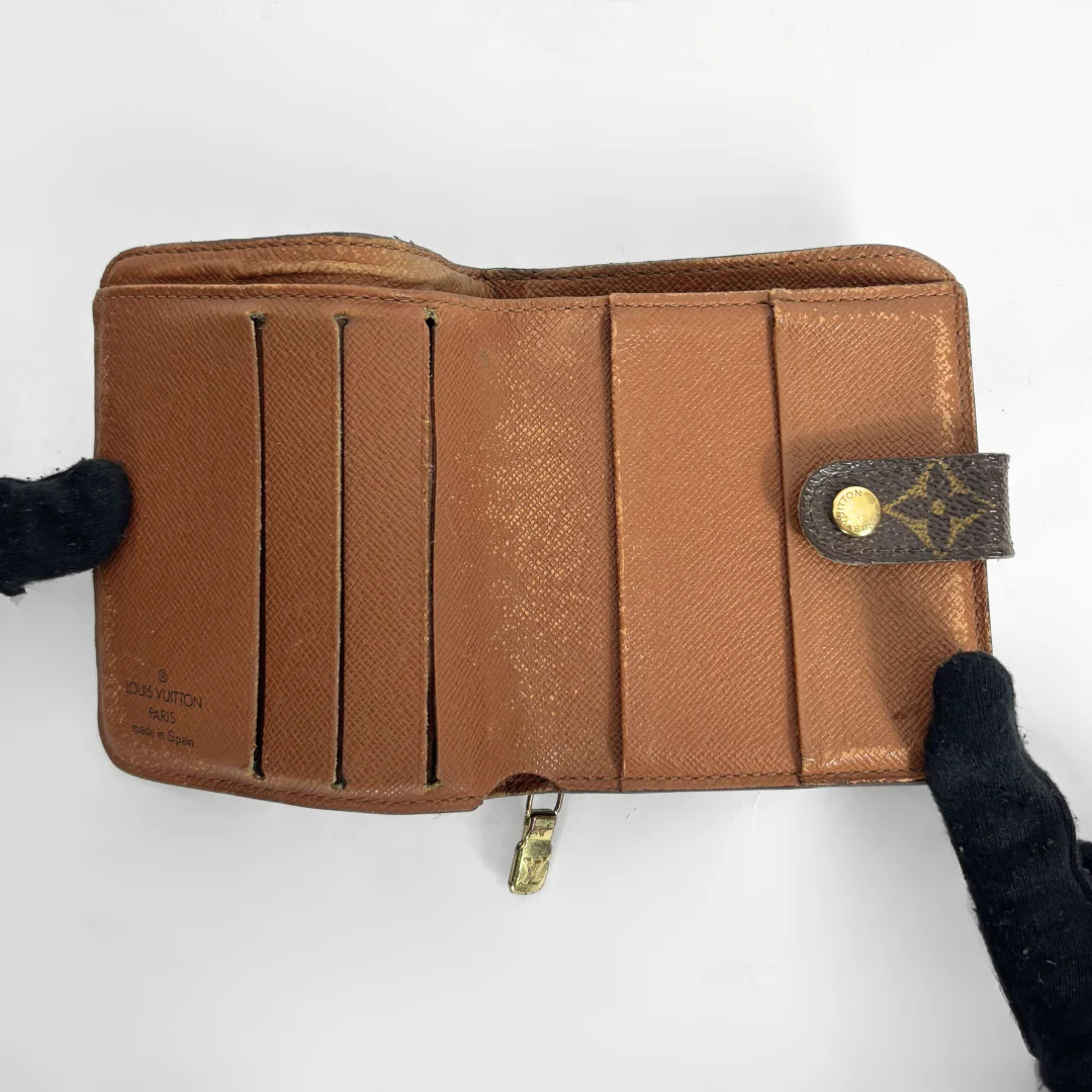 LV compact wallet in signature brown monogram canvas with a snap-button strap closure.