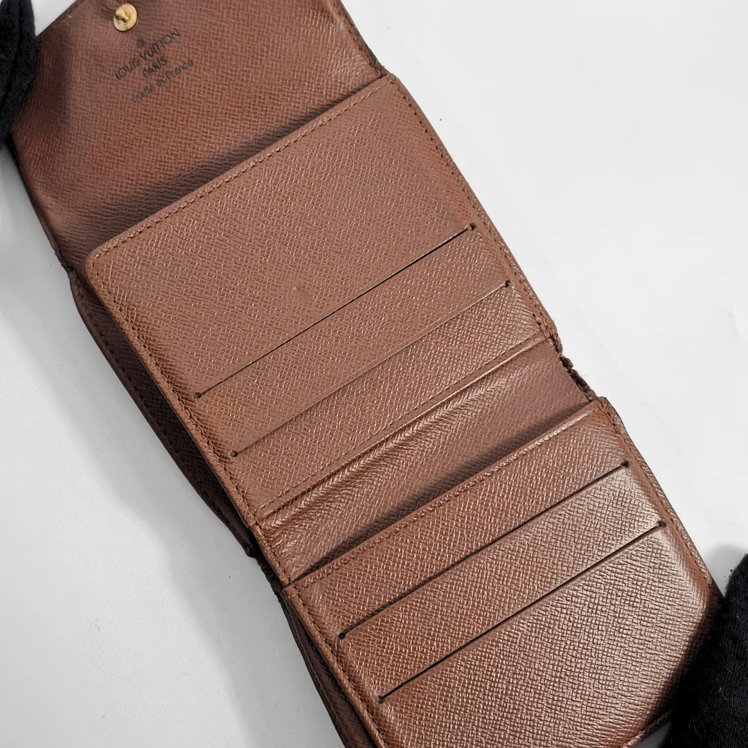 Brown leather wallet with visible stitching on a light gray background