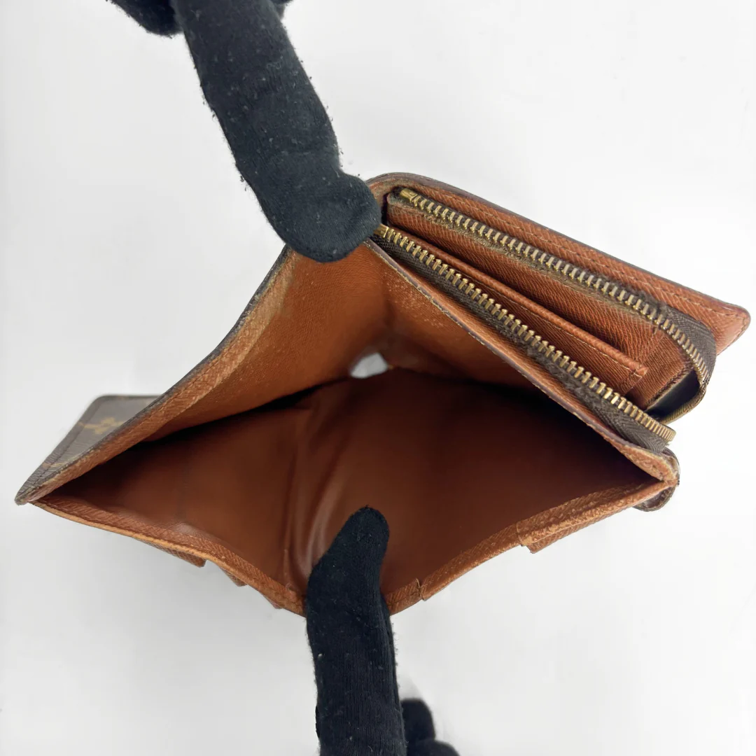 LV compact wallet in signature brown monogram canvas with a snap-button strap closure.