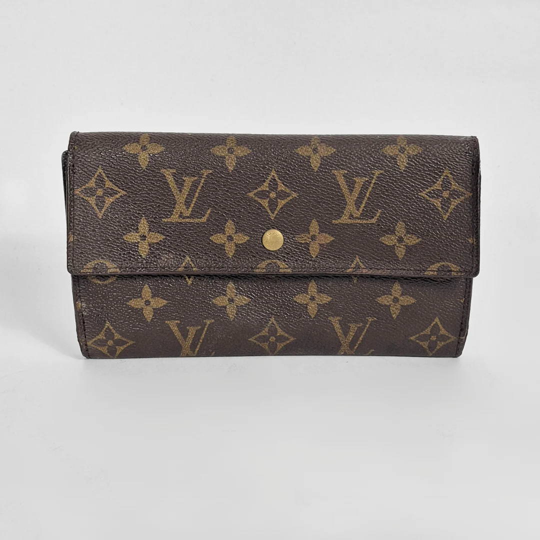 Designer wallet with monogram pattern on a light gray background