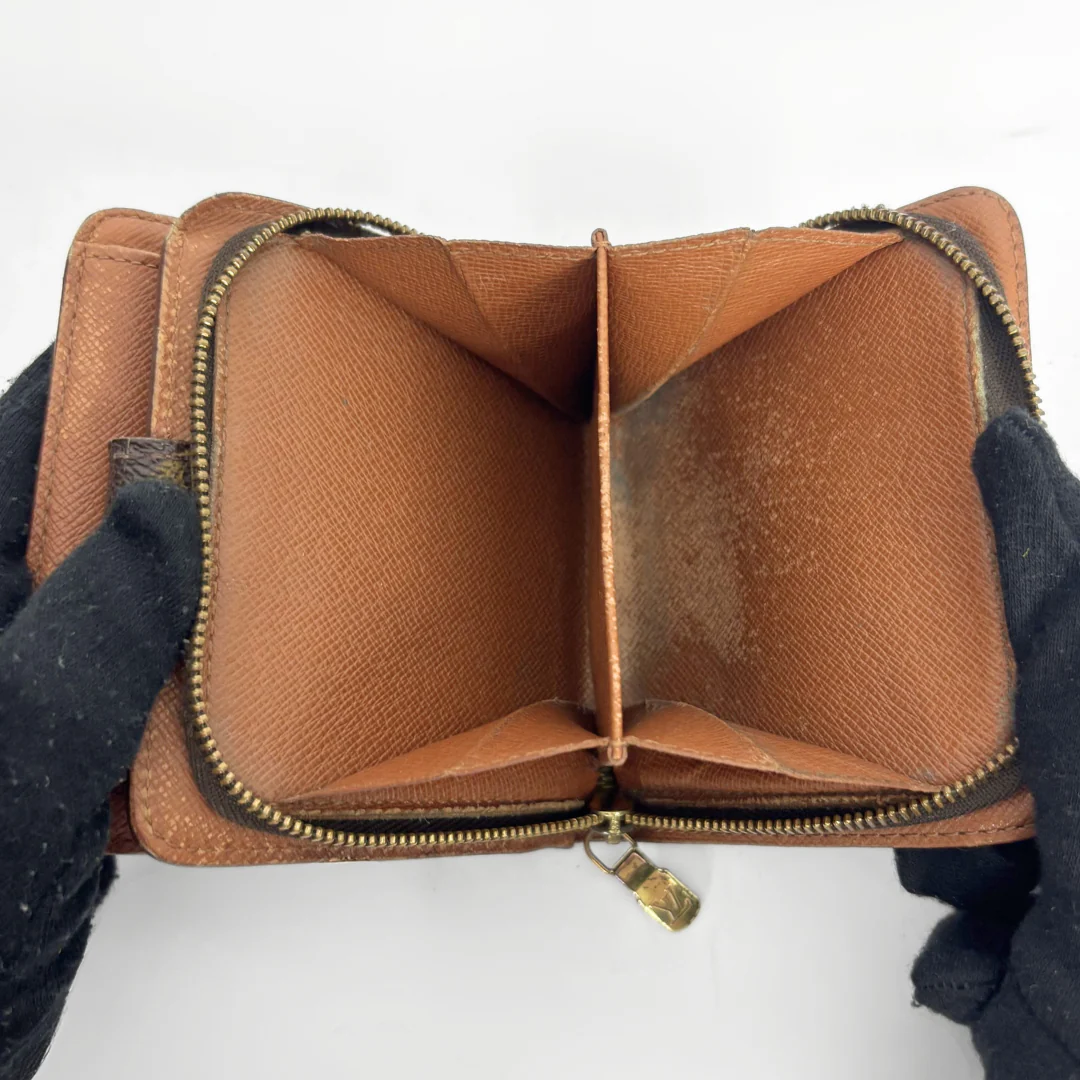 LV compact wallet in signature brown monogram canvas with a snap-button strap closure.