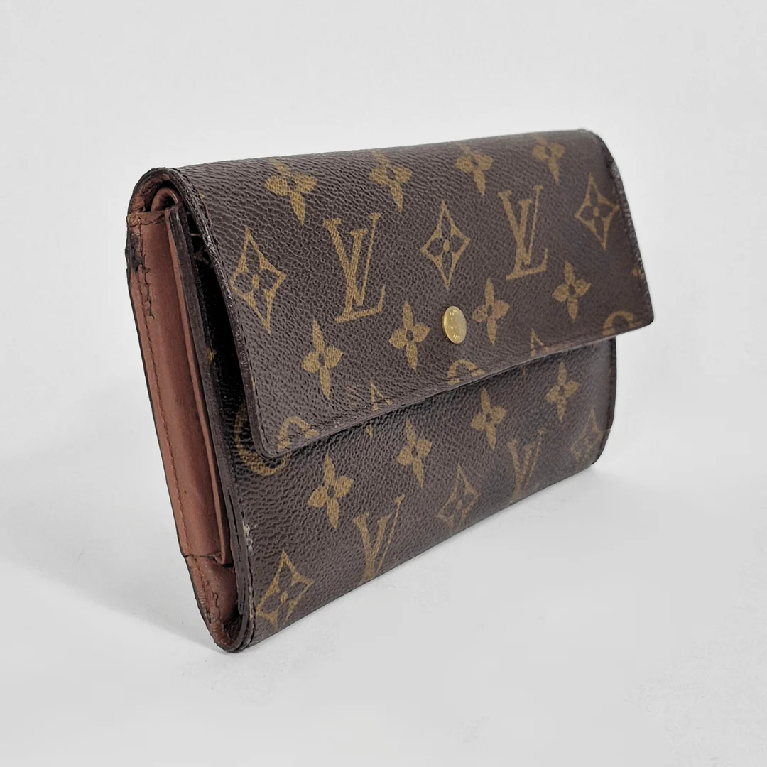 Designer wallet with monogram pattern on a light gray background