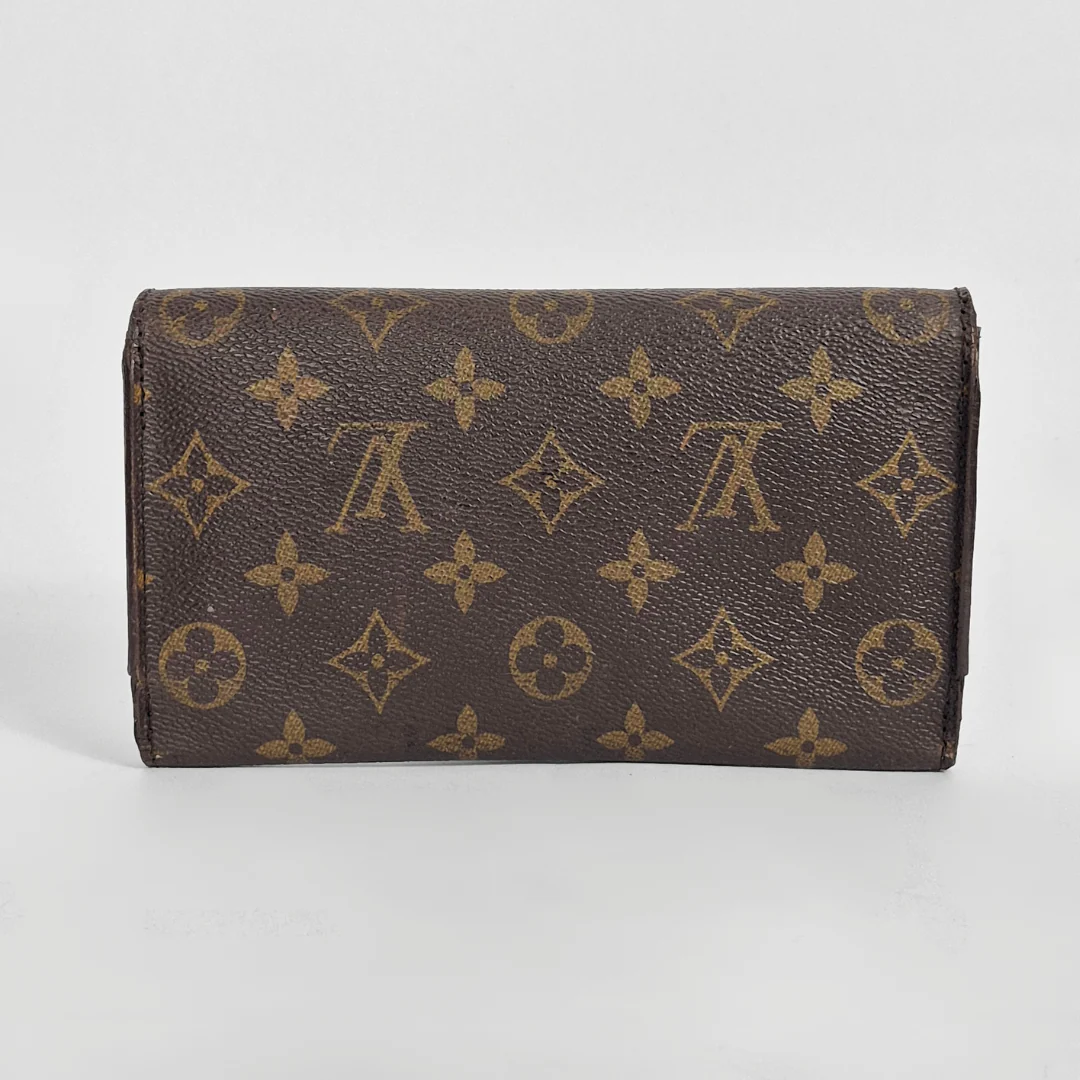 Designer wallet with monogram pattern on a light gray background