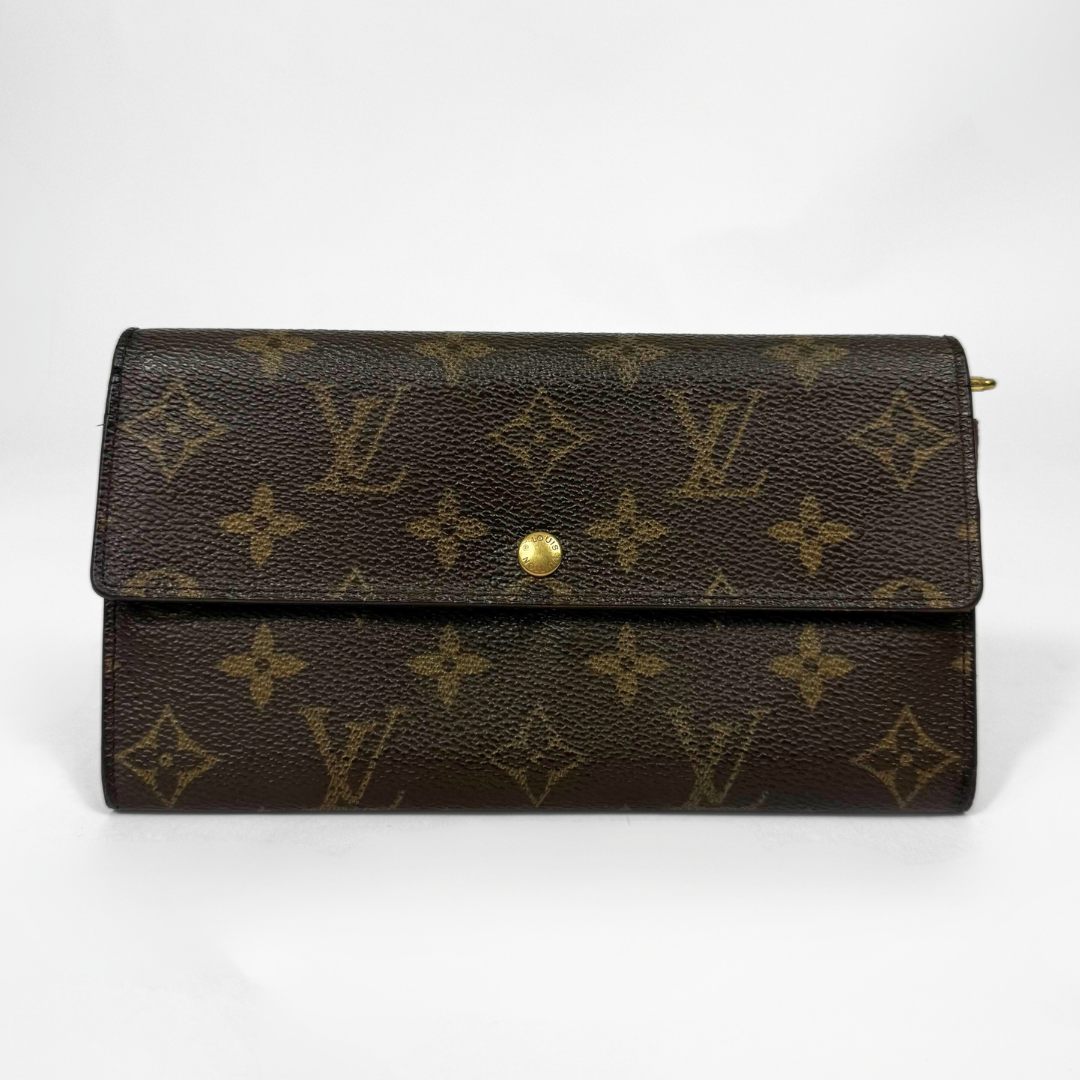 Brown leather wallet with gold monogram pattern on a white background