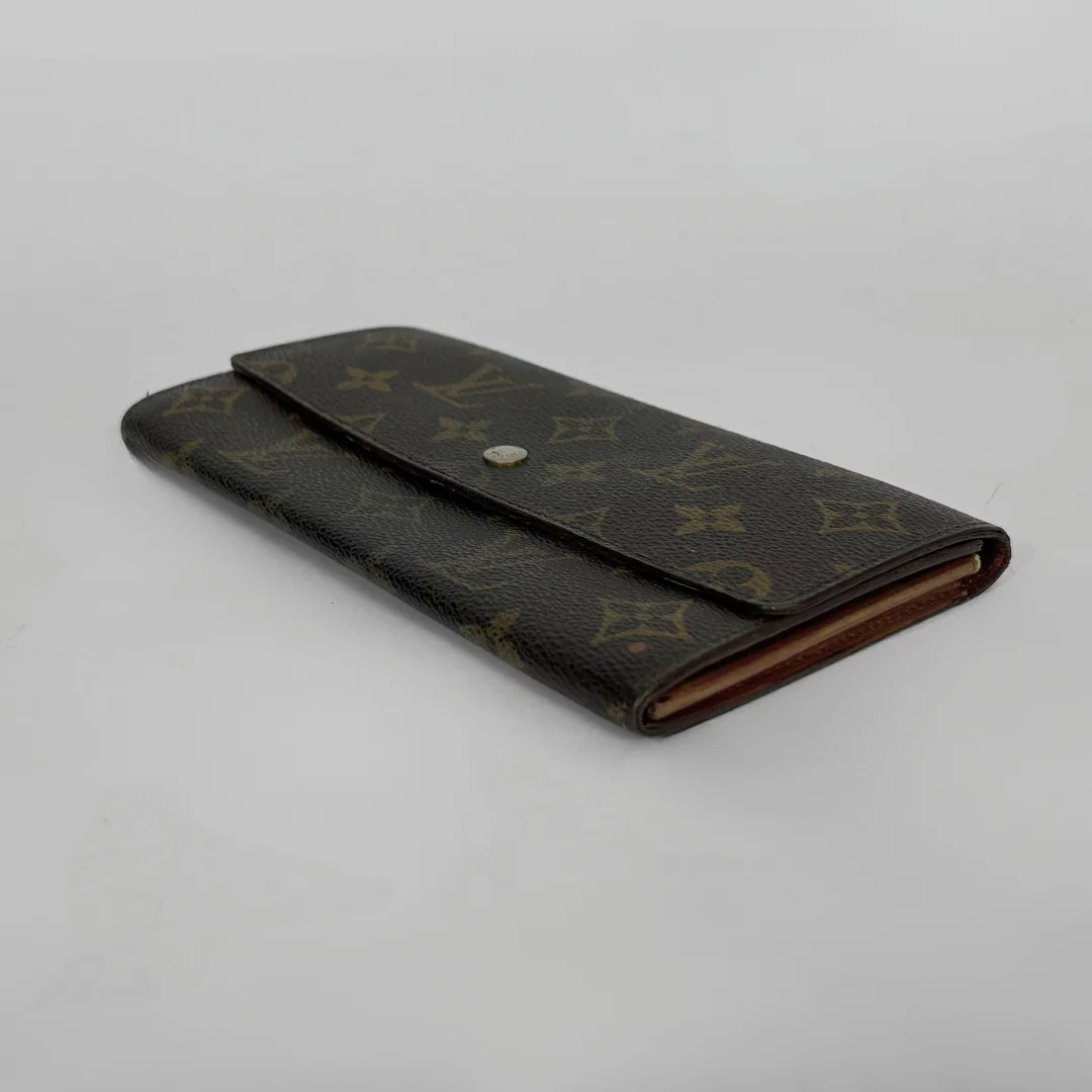 Louis Vuitton wallet with monogram pattern on a white background
