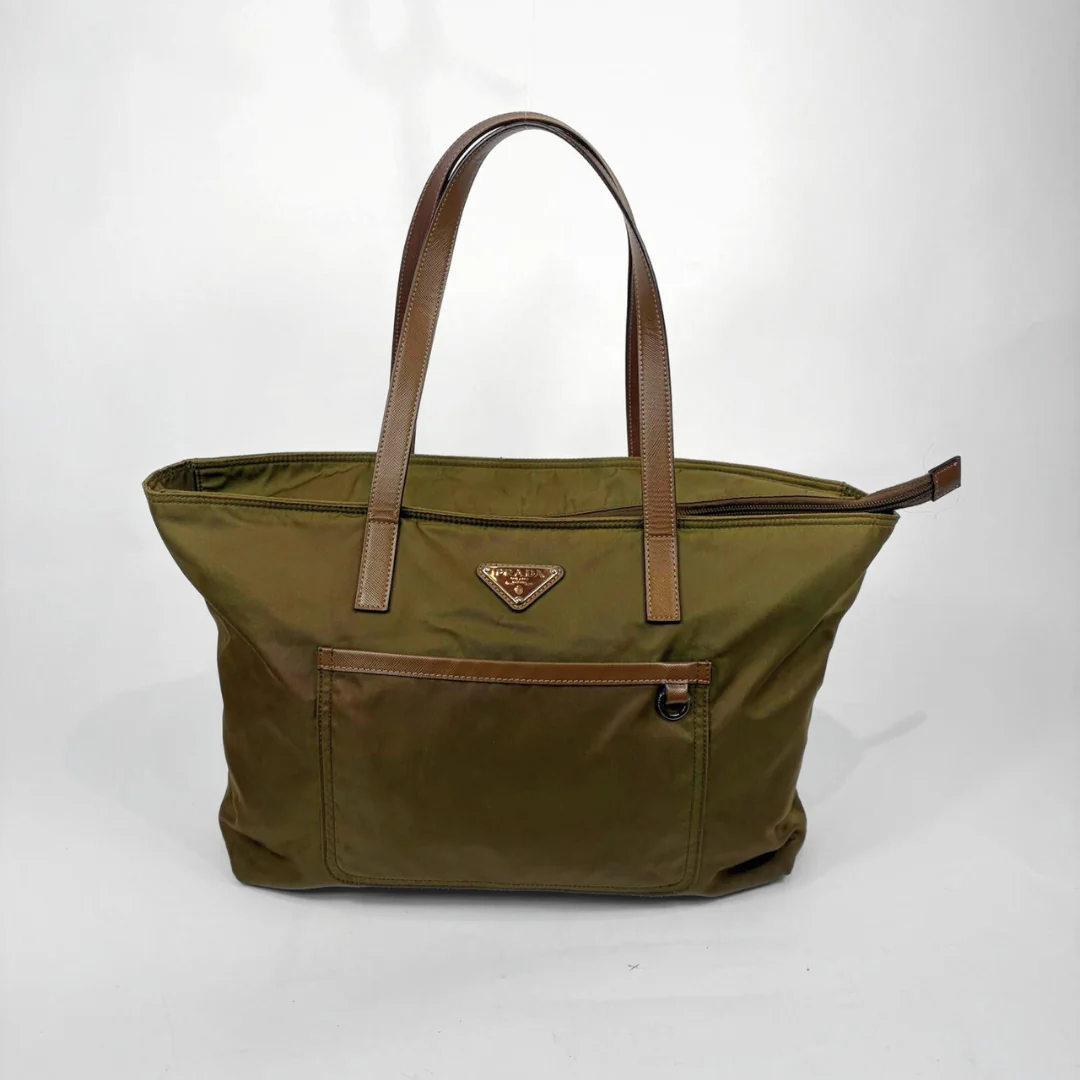 Green tote bag with brown handles and trim on a white background