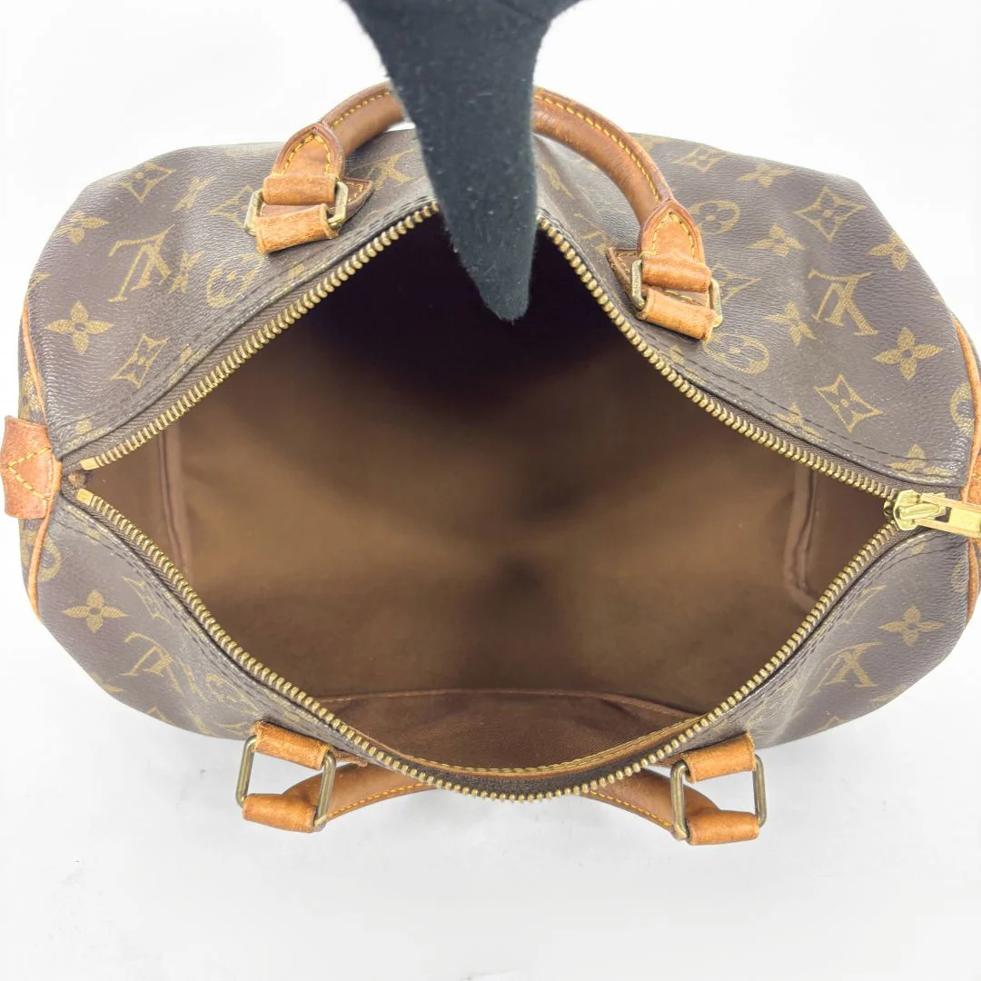 Brown handbag with monogram pattern on a white background