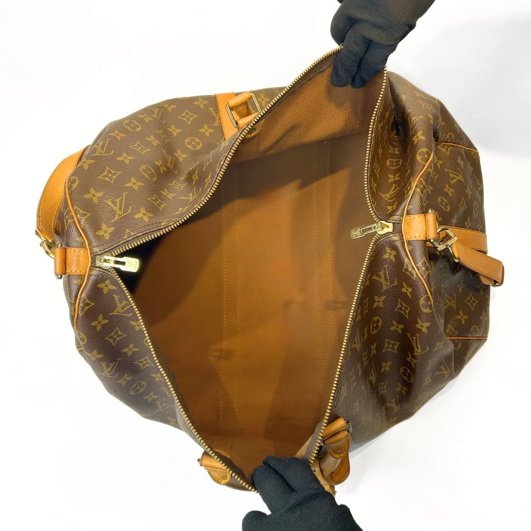 Brown Louis Vuitton bag with monogram pattern held by gloved hands on a white background