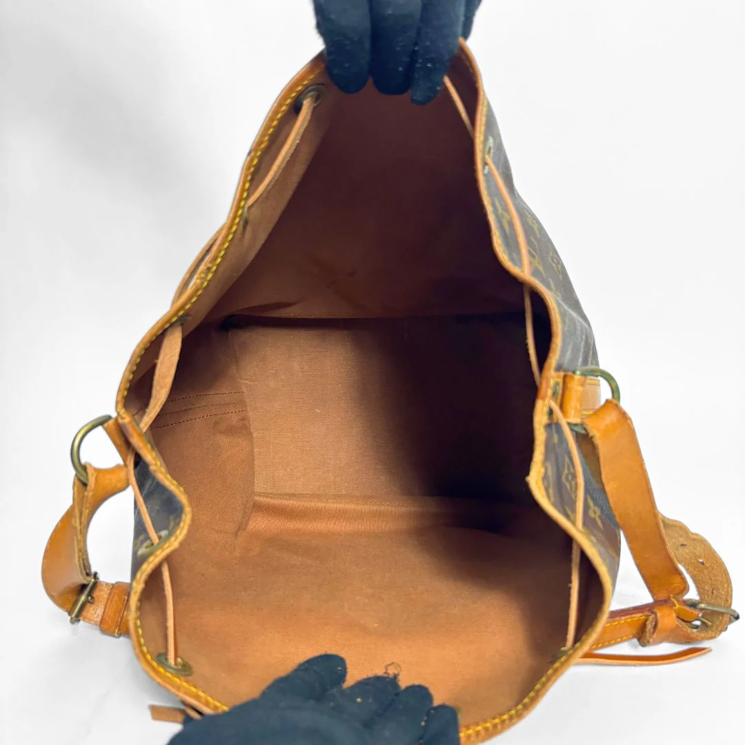 Brown leather handbag with visible stitching on a white background
