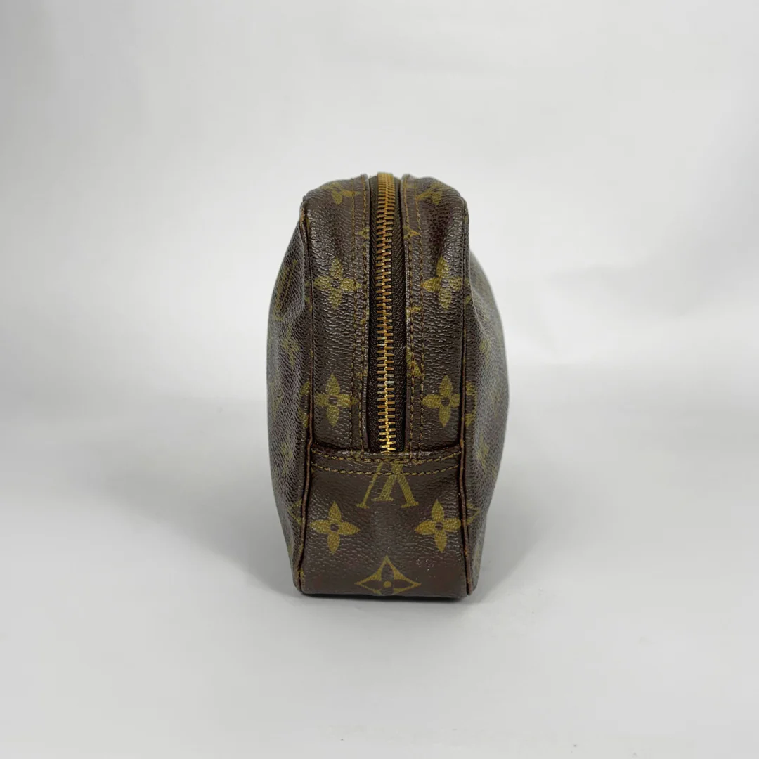 Brown leather toiletry bag with gold zipper on a white background
