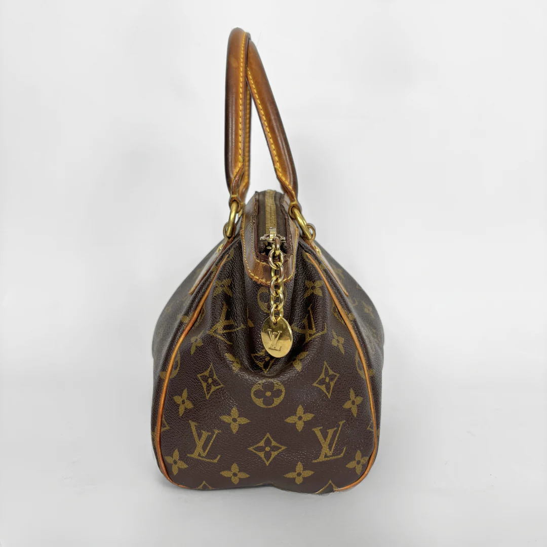 Brown handbag with gold accents on a white background