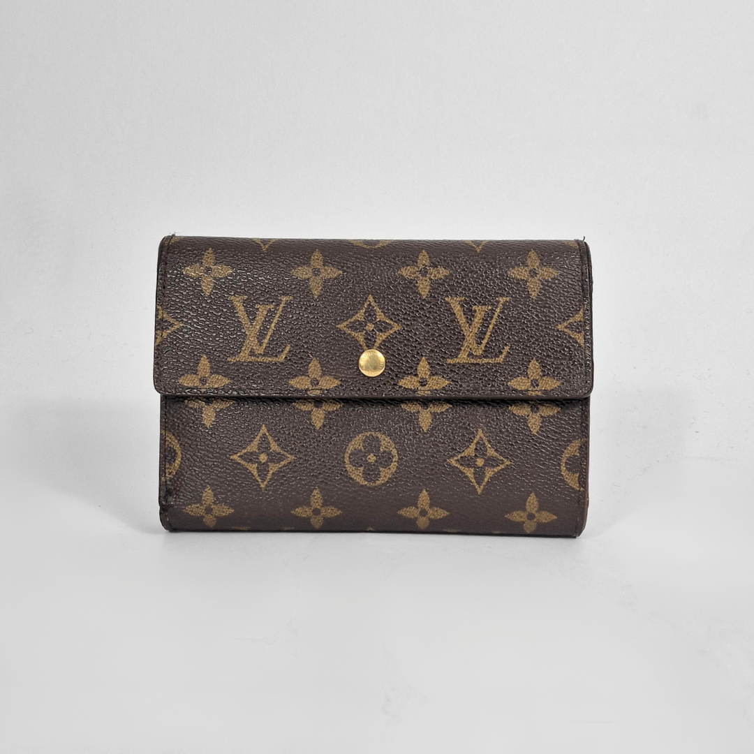 Louis Vuitton wallet with monogram pattern on a light gray background