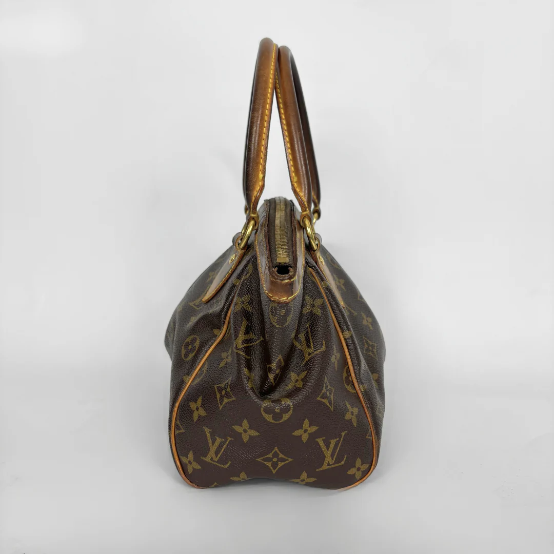Brown handbag with gold accents on a white background