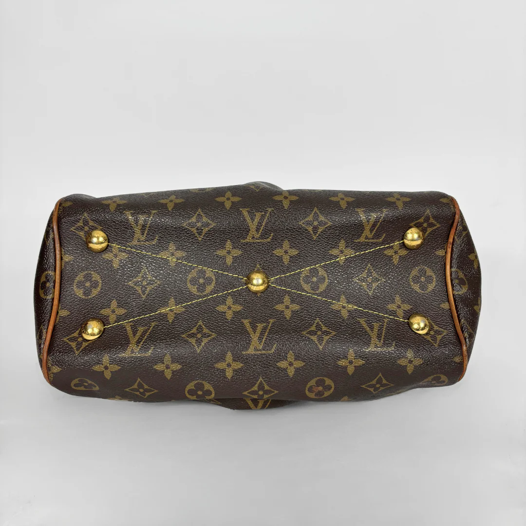 Brown handbag with gold accents on a white background