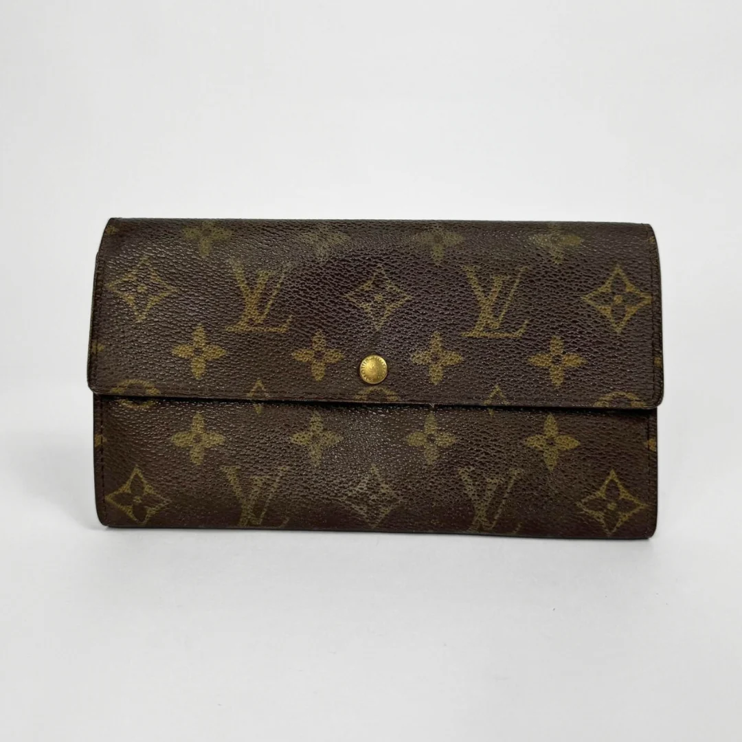 Brown wallet with gold monogram pattern on a white background