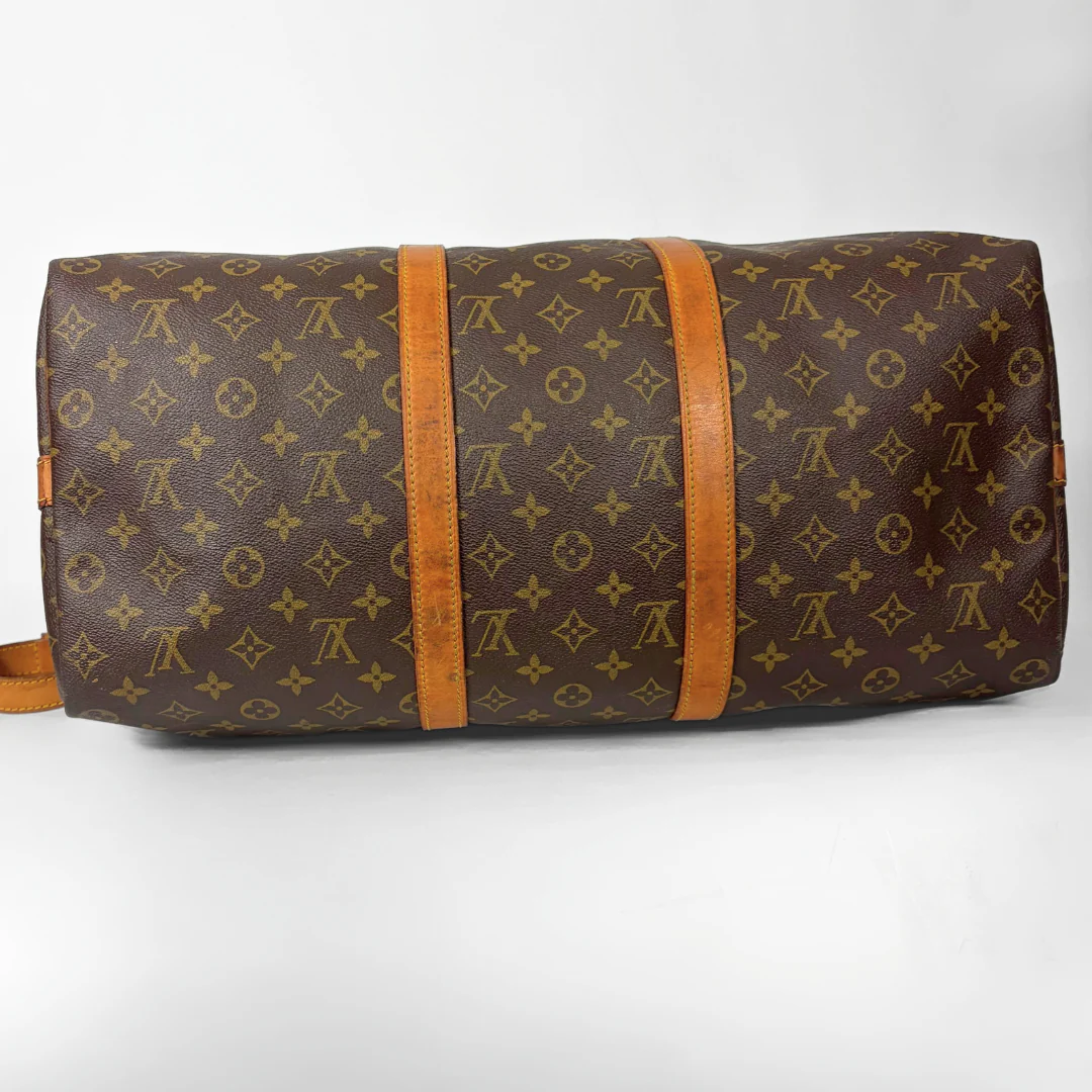 Brown duffel bag with monogram pattern on a white background