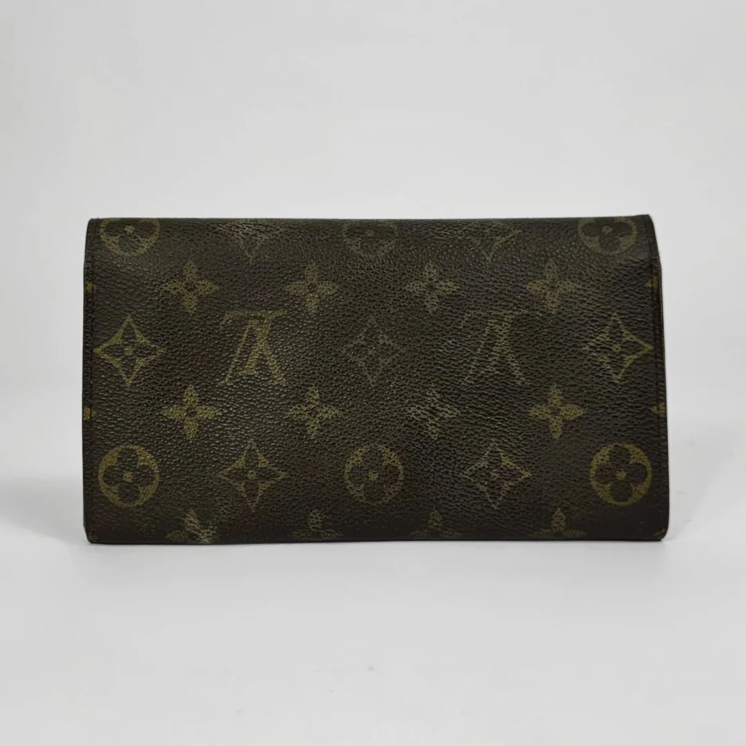 Brown wallet with gold monogram pattern on a white background