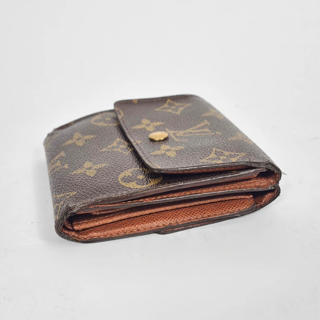 Brown wallet with gold monogram pattern on a light gray background