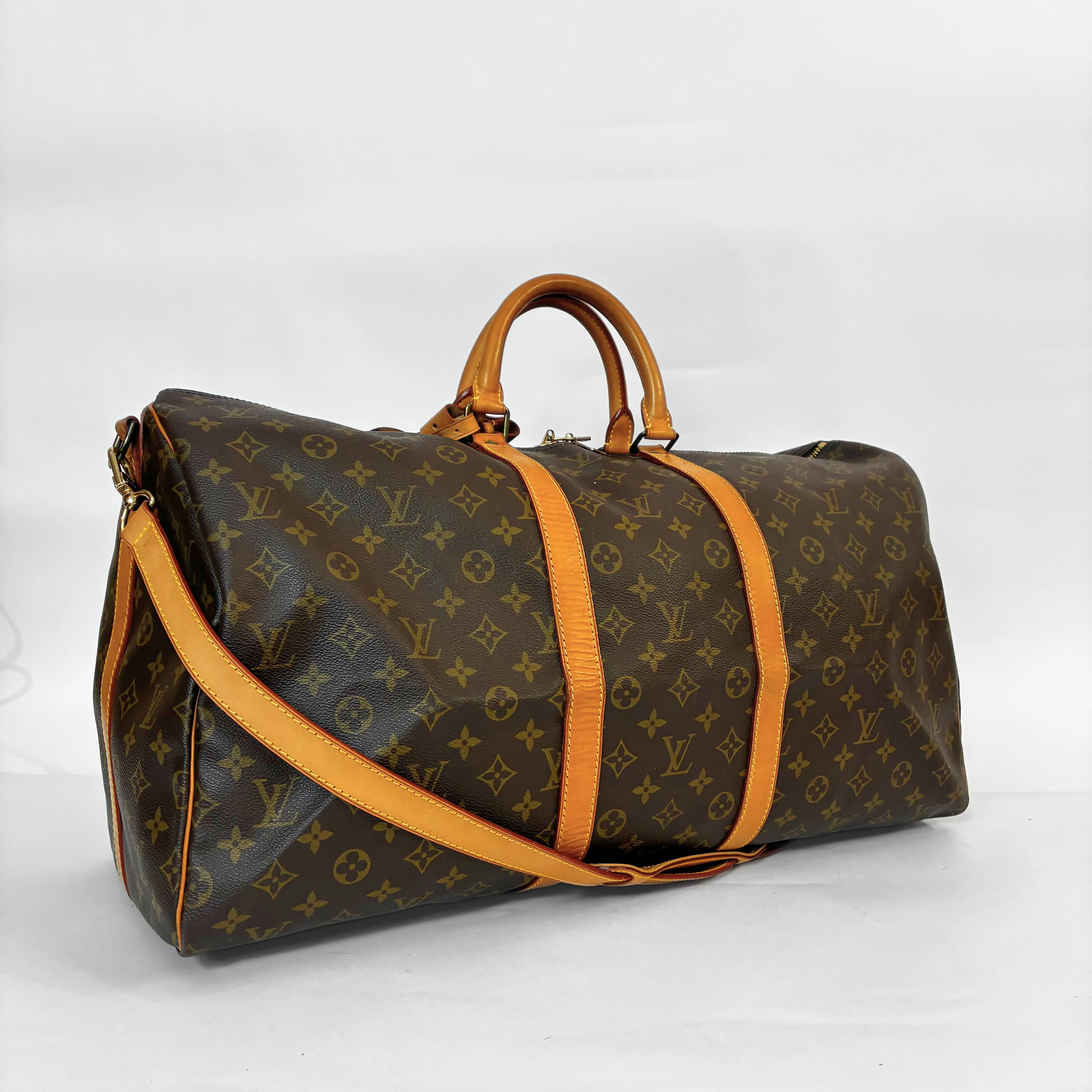 Designer travel bag with monogram pattern on a white background
