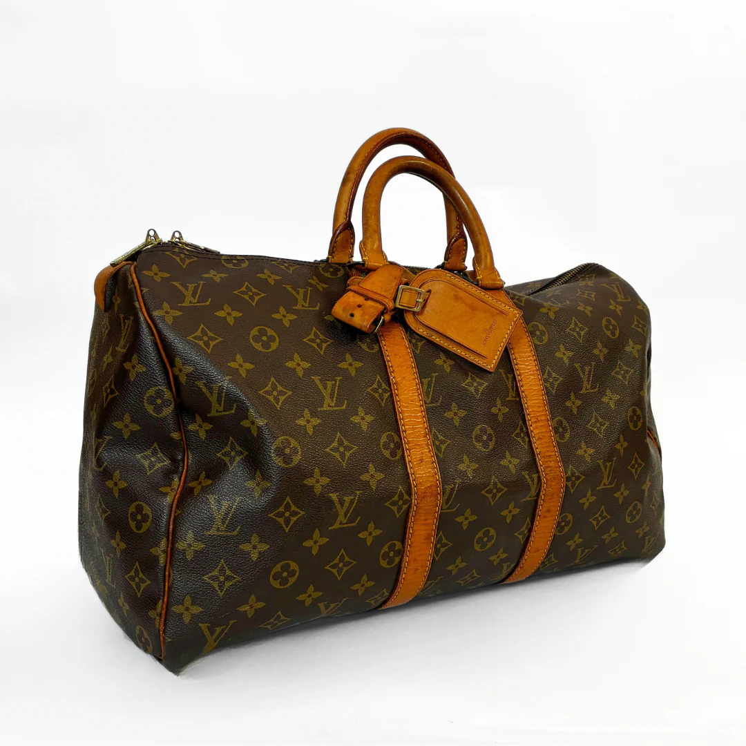 Brown leather handbag with orange accents on a white background