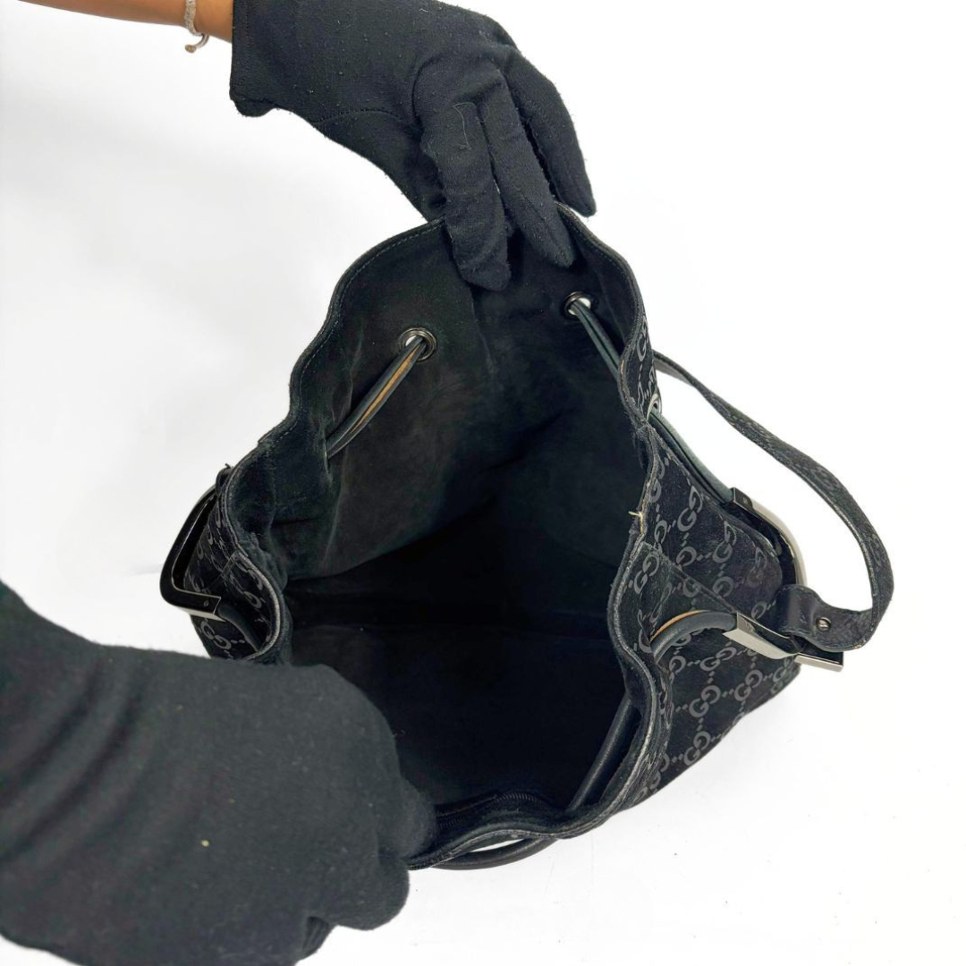 Gucci GG black suede shoulder bag on a white background