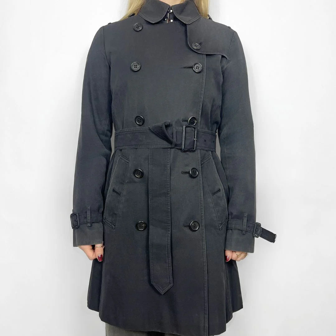 Dark gray trench coat worn by a person on a white background