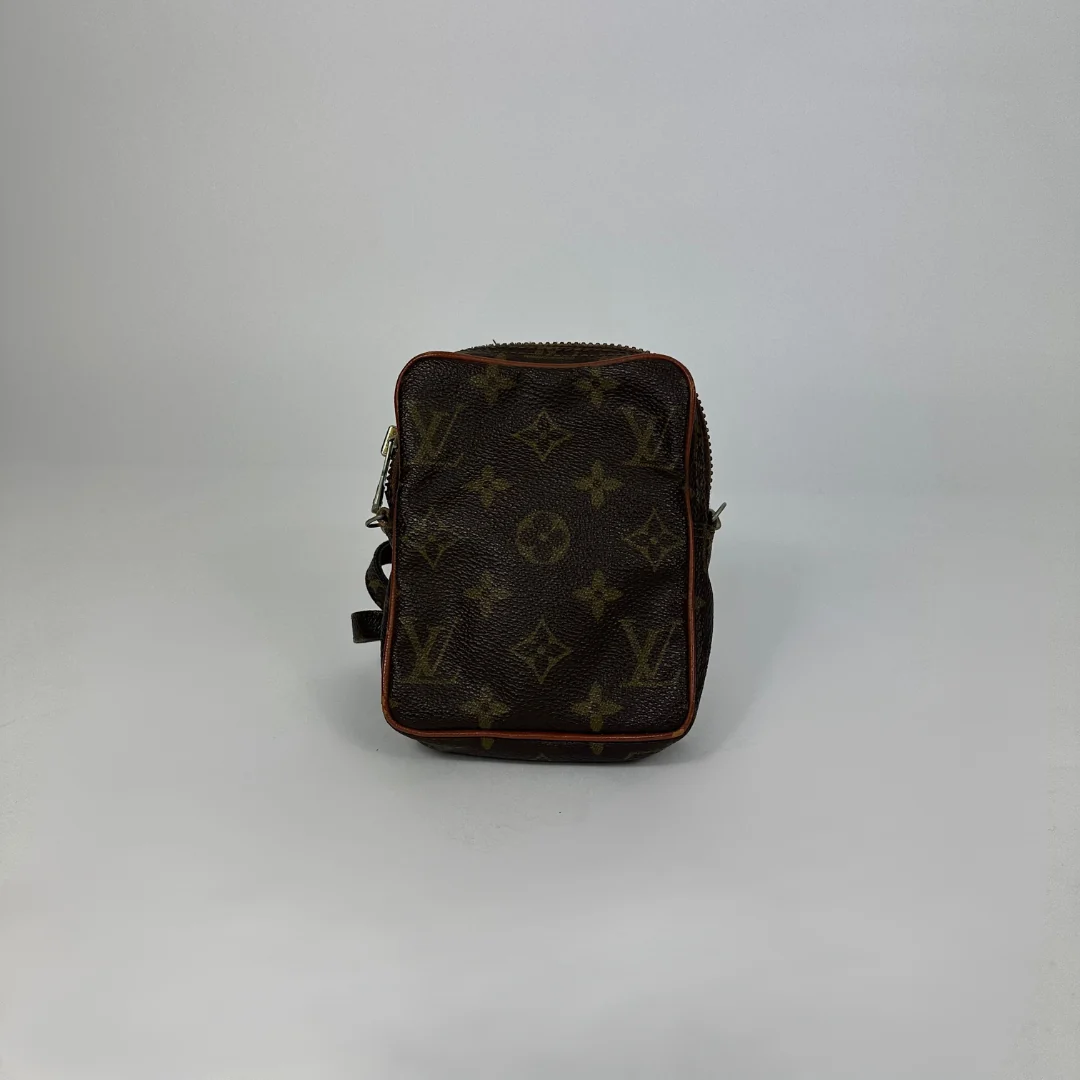 Black leather bag with brown monogram pattern on a white background