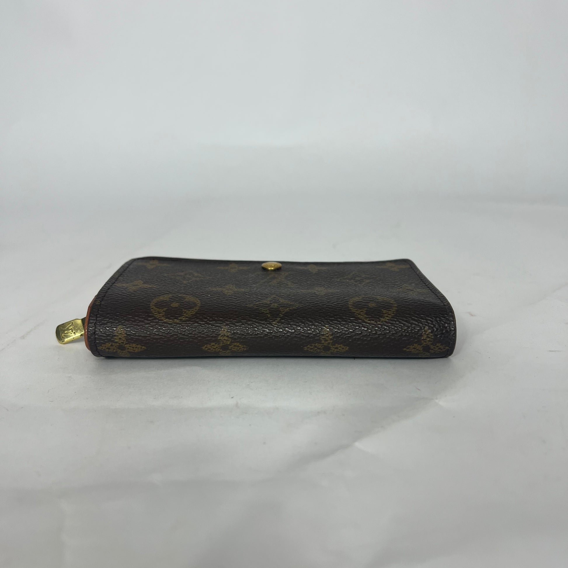 Black leather wallet with gold accents on a white background