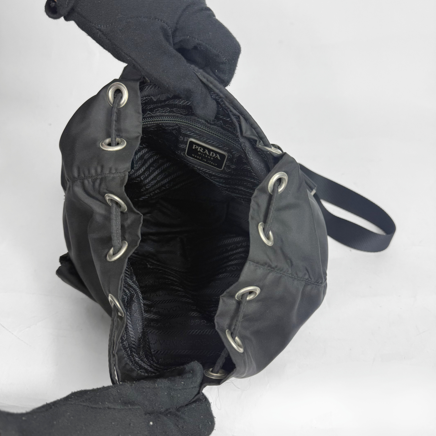 Black Prada handbag with drawstring closure on a white background