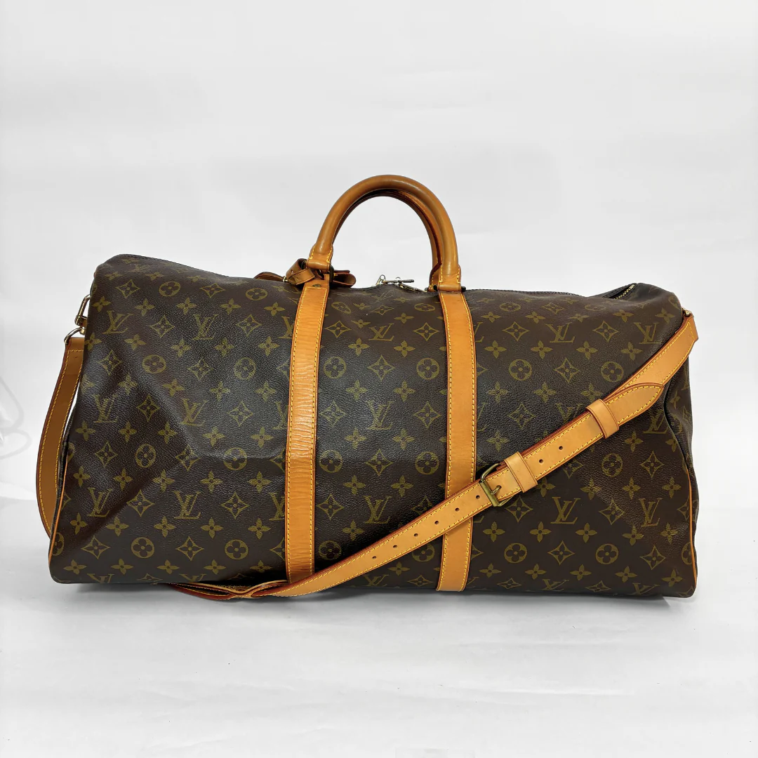 Louis Vuitton monogram travel bag with brown leather straps on a white background